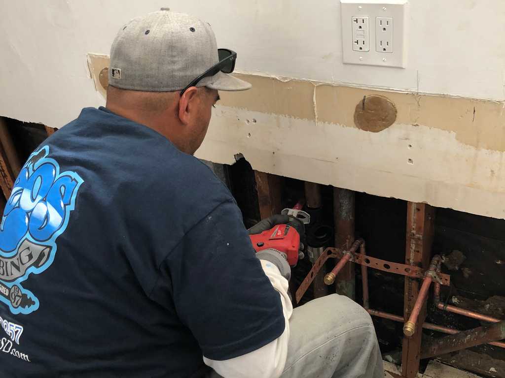 a2mContractors cuts out the old water and sewer pipes on a bathroom remodel