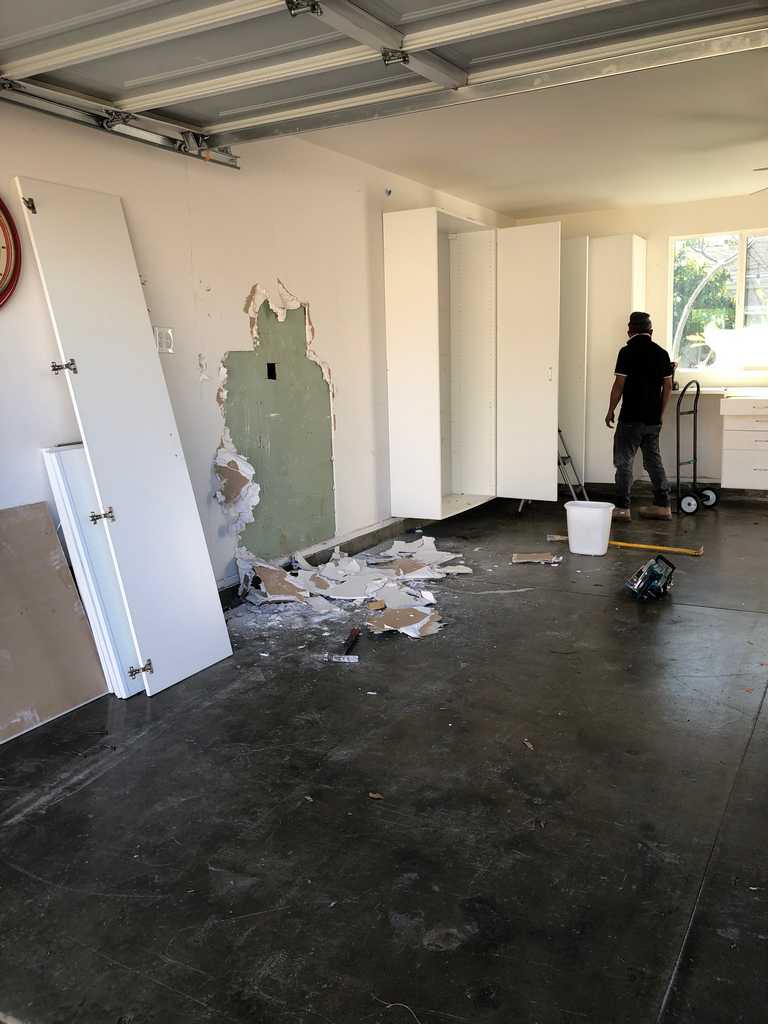 garage conversion workers removing the old wall