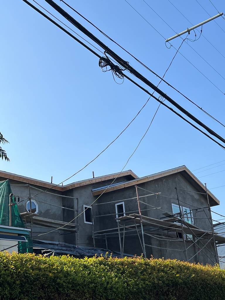 Side elevation showing top-level stucco and working scaffolds.