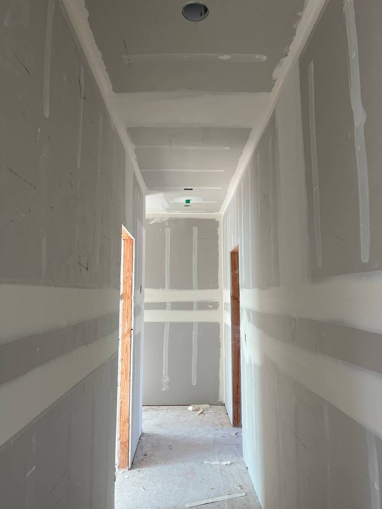 Drywall completed in corridor with taped and mudded joints.