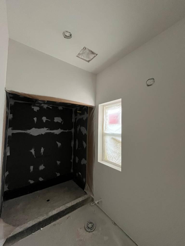 Shower area with cement board waterproofing applied in remodel project.