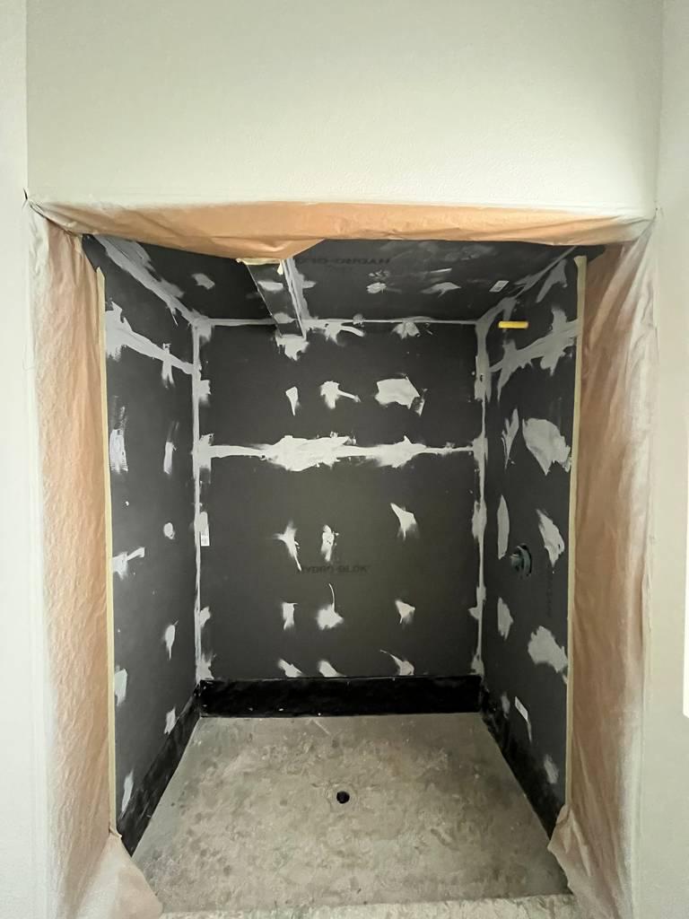 Remodel progress showing cement board and drywall prep in shower.