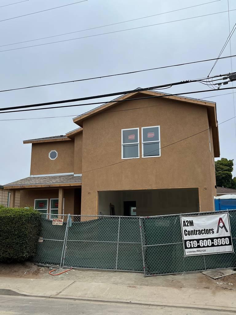 Exterior view showing stucco application and installed windows.