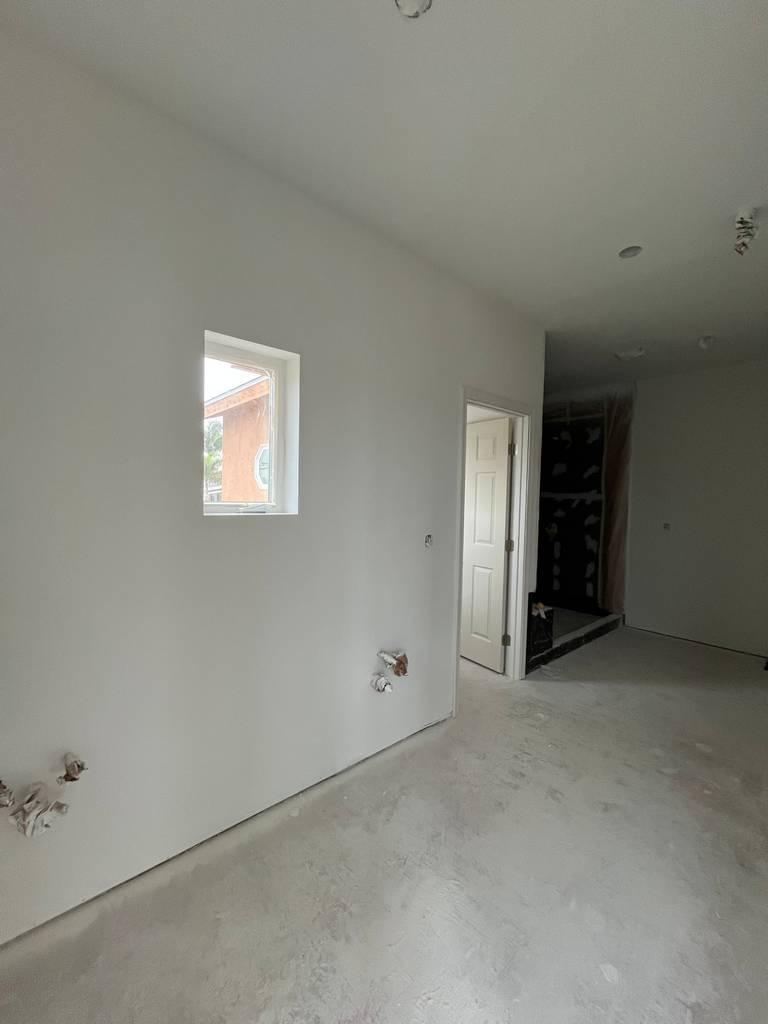 Drywall progress with taped joints and framed wall openings.