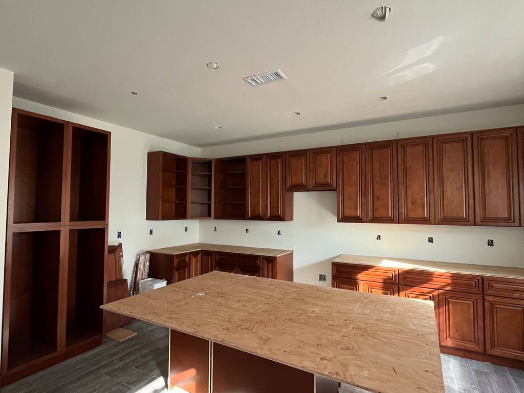 Cabinetry and island base installation in open kitchen space.