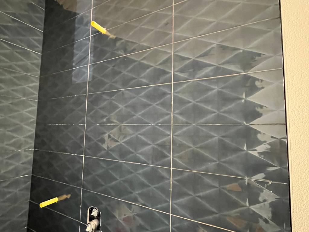 Close-up of blue textured shower wall tile alignment.
