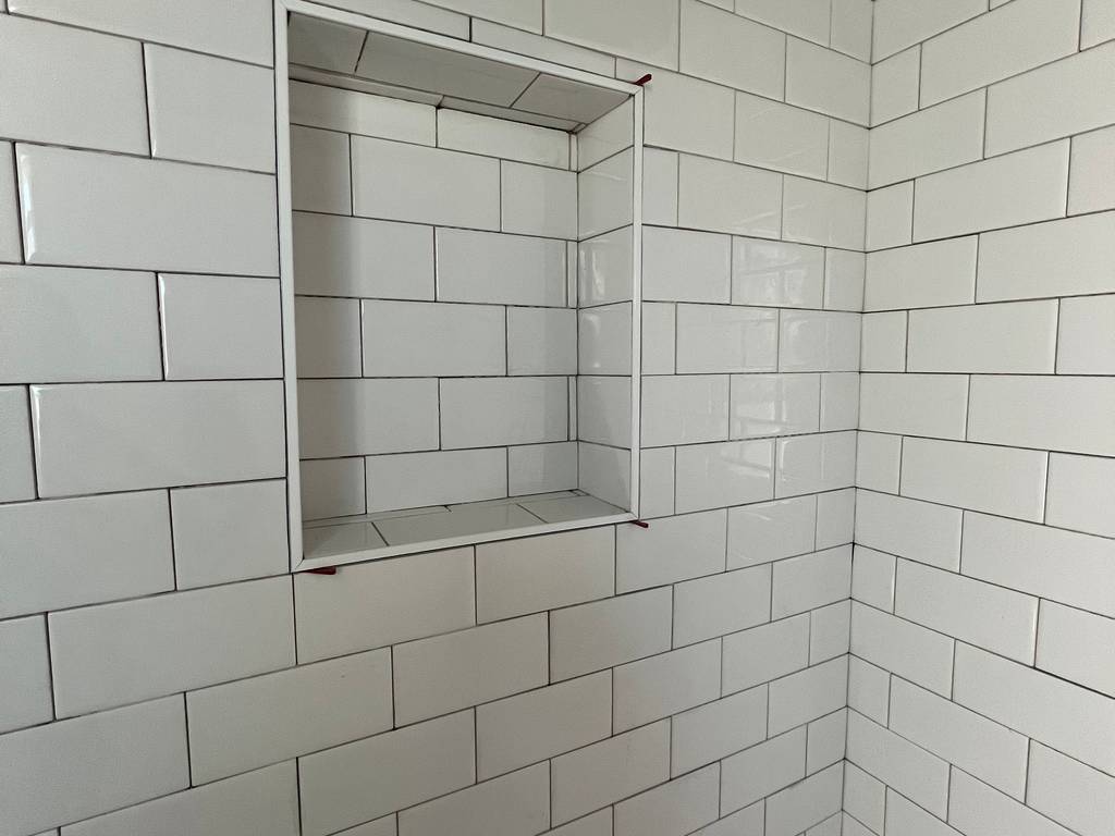 White subway tile shower niche framed and ready for grout.