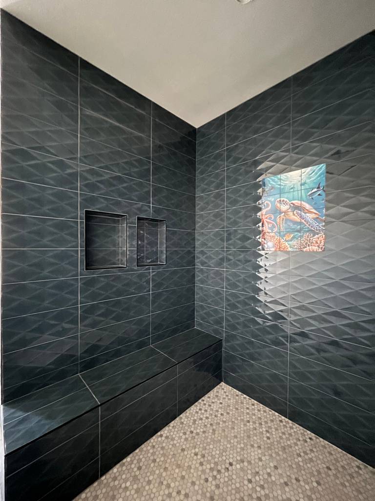 tiled shower showing built-in bench seating, dual niches