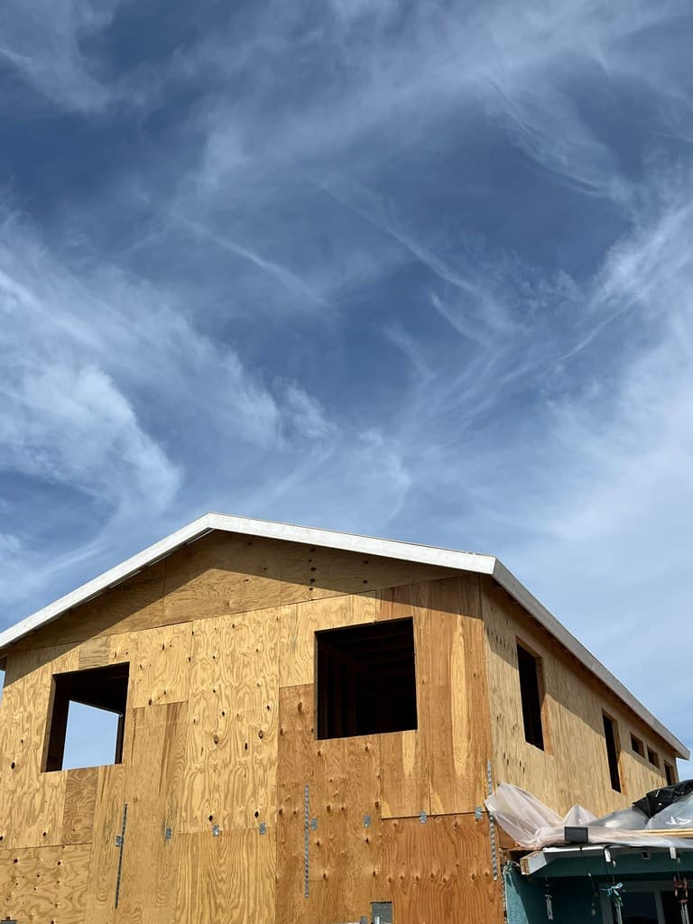 ADU roofline sheathing with upper window openings.