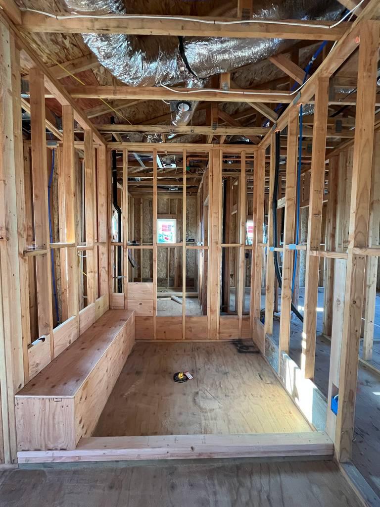 Framed shower bench and drain assembly set in place before waterproofing and tile prep