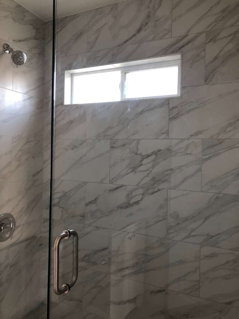 ADU-showing-beautifully-designed-walk-in-shower-with-marble-panel-walls