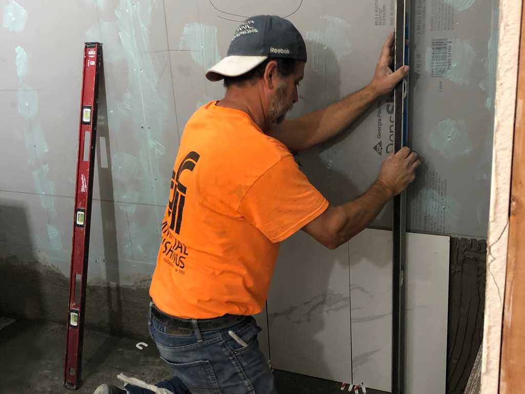 a2mContractors showing proferssional tile worker attaching marble tile
