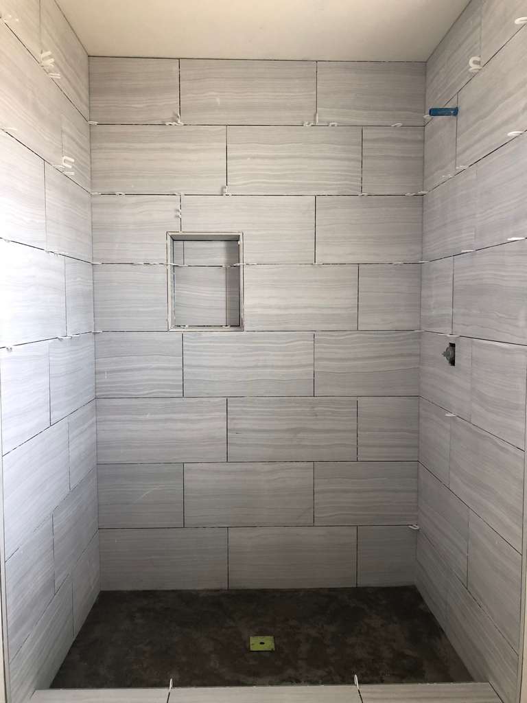 ADU-showing-walk-in-shower-marble-tile-panel-work
