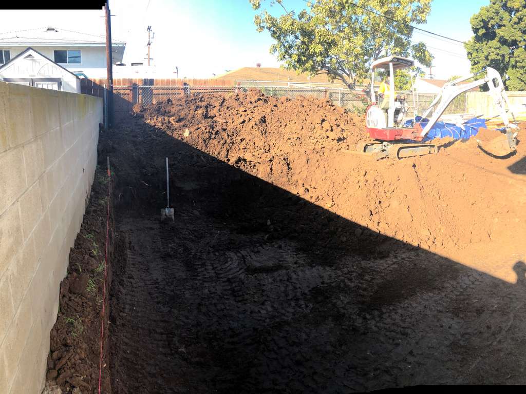 backhooe digging the foundation for the home addition