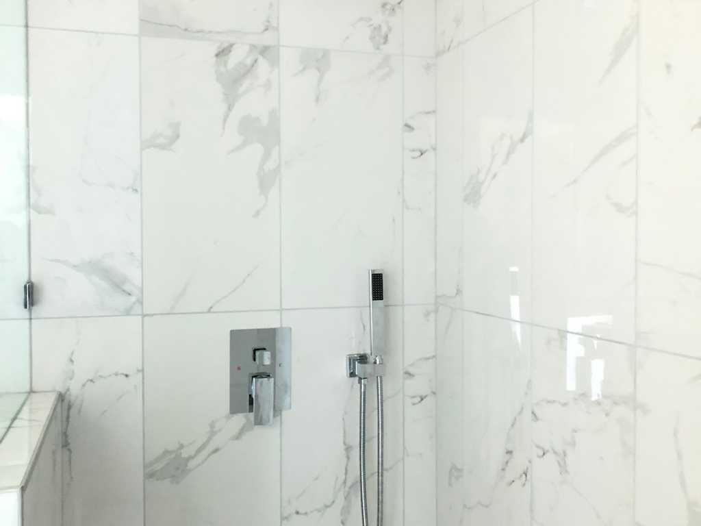 ADU showing custom design marble shower and fixtures
