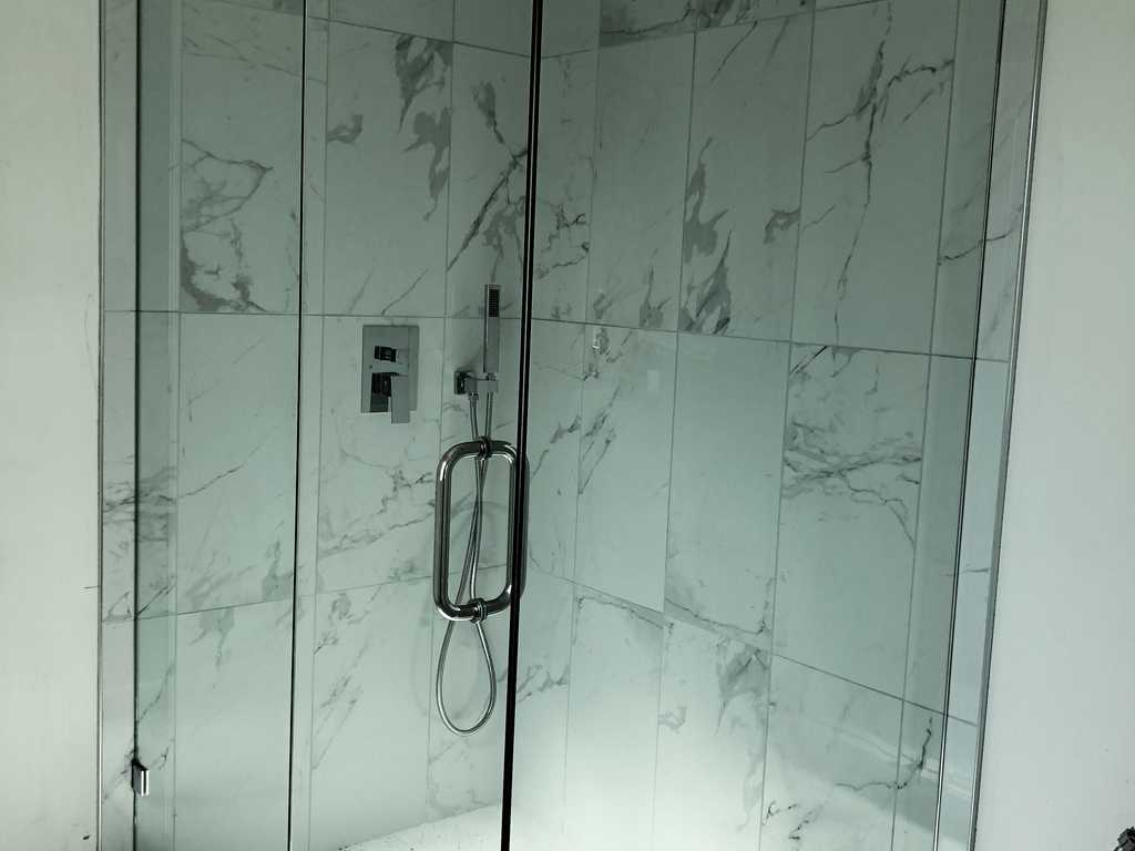 ADU showing glass enclosure with a marble shower