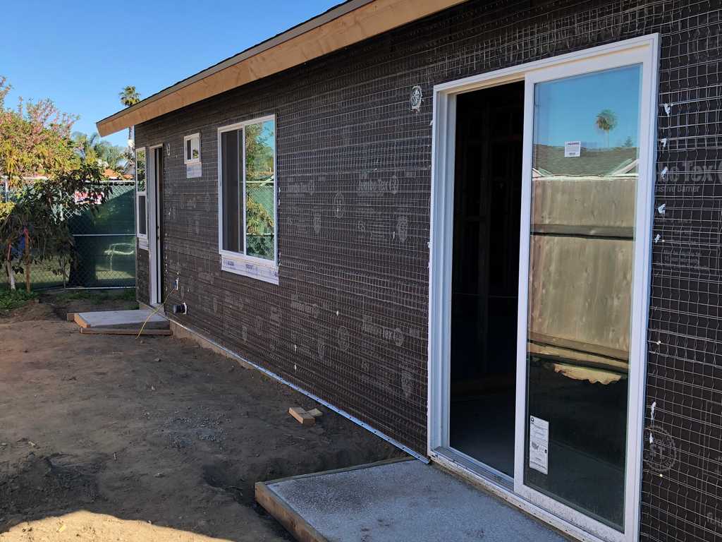 ADU showing back yard stucco paper and vinyl slider and windows