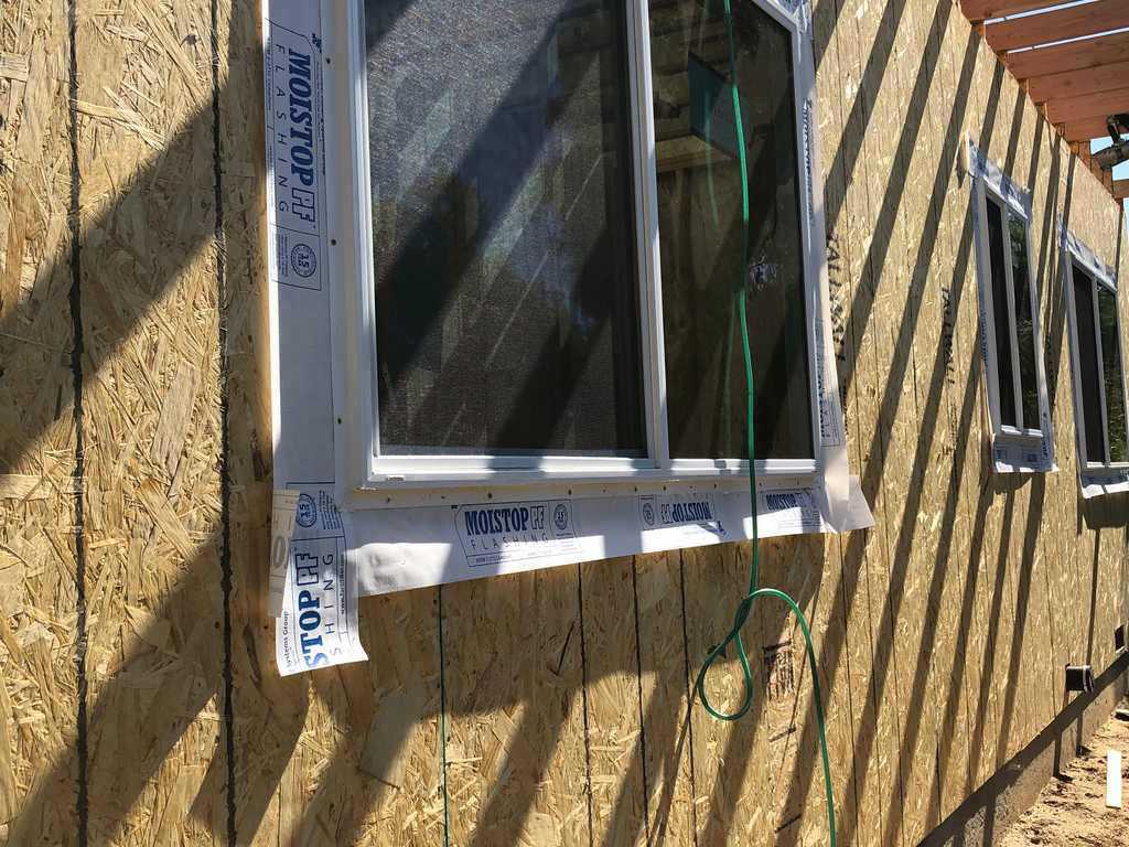 ADU applying weather-resistive barrier for vinyl windows