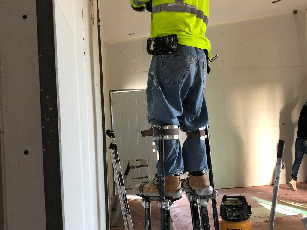 ADU drywall worker mudding the joints an screws