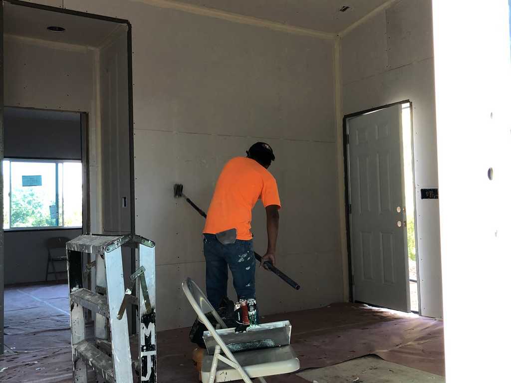 ADU worker sanding the drywall joints